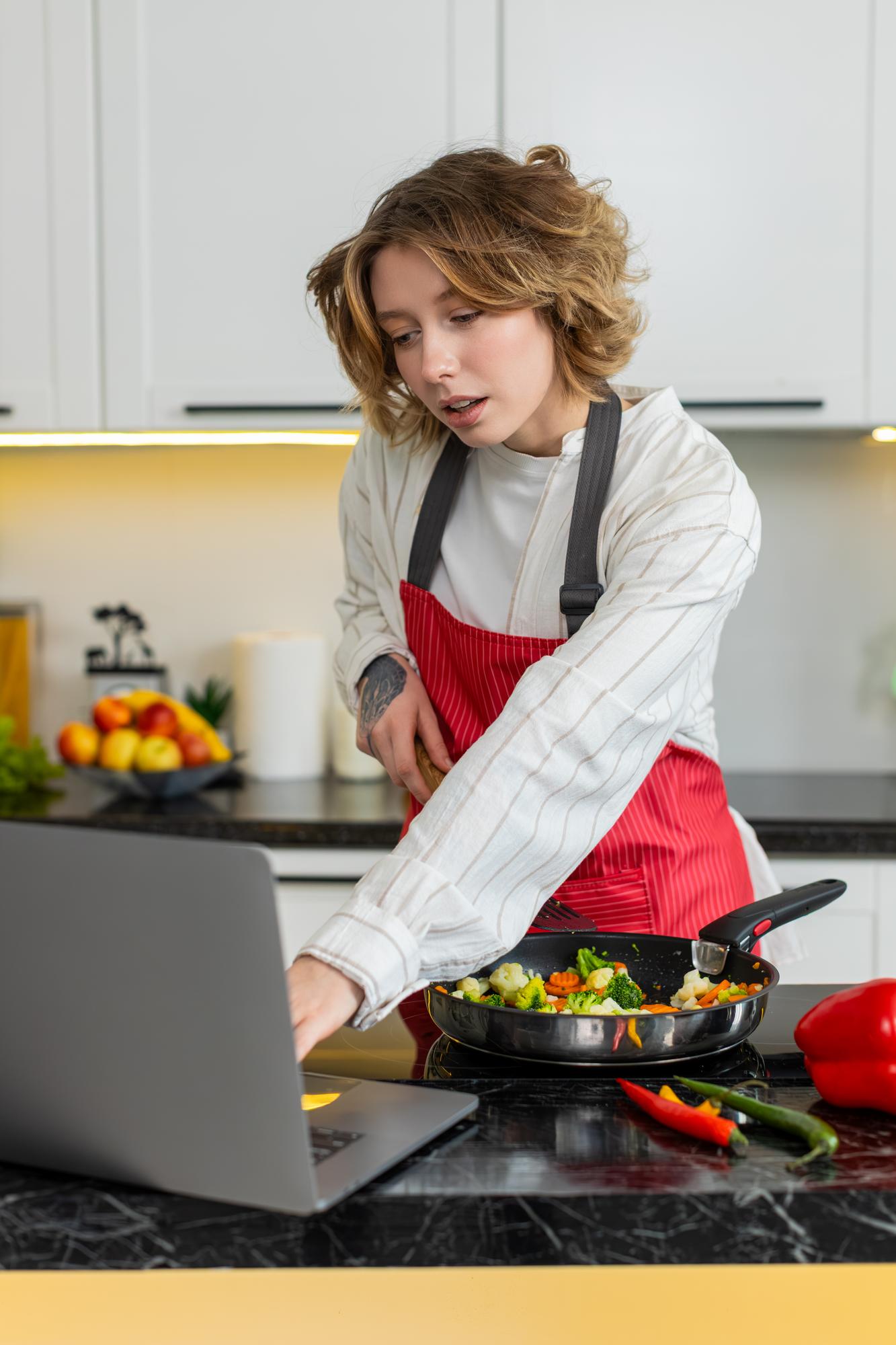 Student cooking at home with laptop